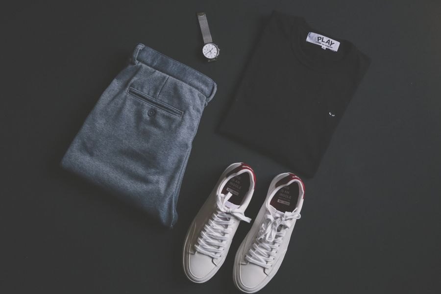 Photographic flat lay of a black tee, jeans, sneakers and a watch